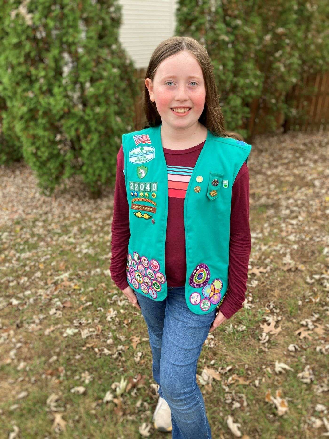 Girl Scout Gracie Ogle wears vest with badges she has earned.