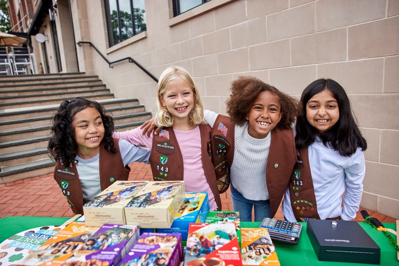 Girl Scouts engaging in the Girl Scout Cookie Program: selling cookies, at cookie booth, eating cookies, with Adventurefuls cookie, meeting customers, volunteer